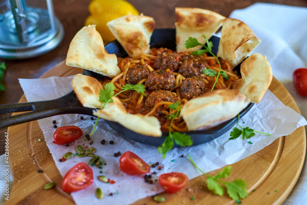 meatballs with pasta, garnished around with bread