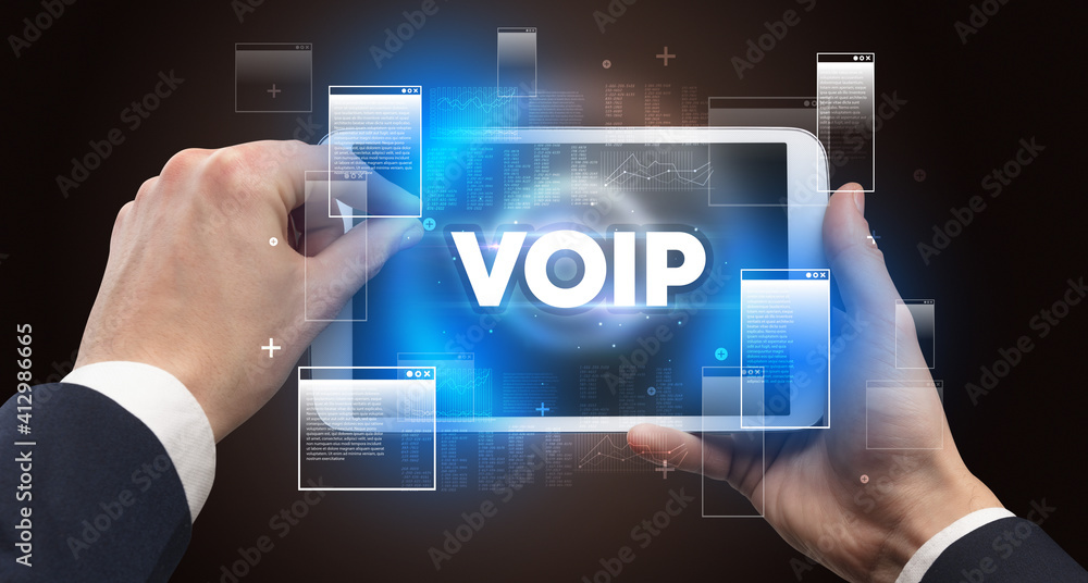 Close-up of a hand holding tablet with VOIP abbreviation, modern technology concept Close-up of a hand holding tablet with VOIP abbreviation, modern technology concept