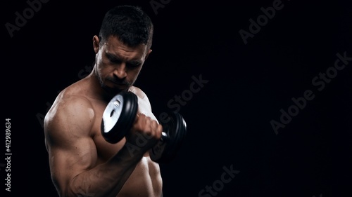 Fit and sporty bodybuilder over black background. Sportsman in studio. Sport and fitness concepts. © Acronym