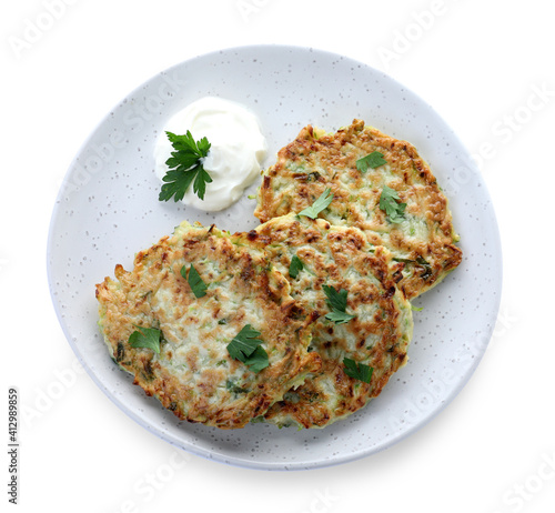 Delicious zucchini fritters with sour cream and parsley isolated on white, top view