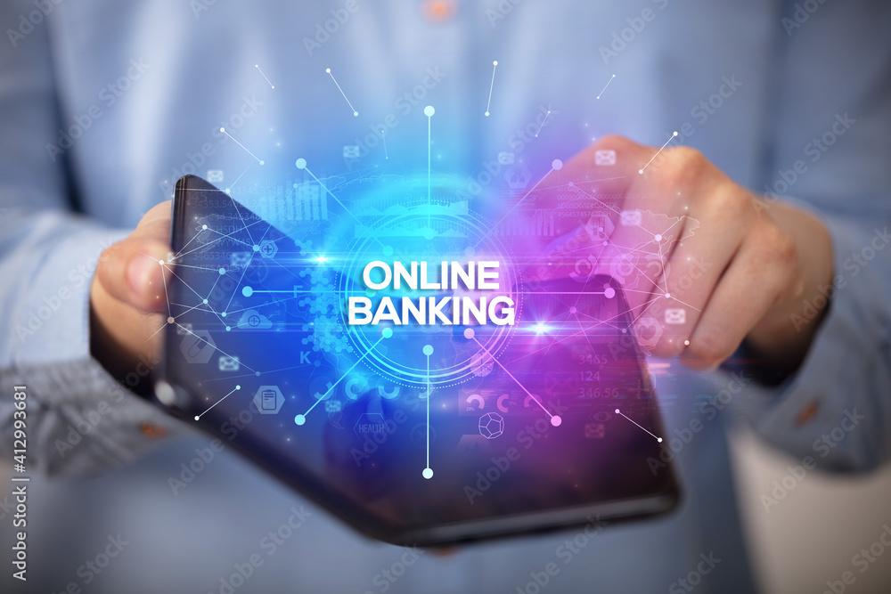 Businessman holding a foldable smartphone with ONLINE BANKING inscription, new business concept Businessman holding a foldable smartphone with ONLINE BANKING inscription, new business concept