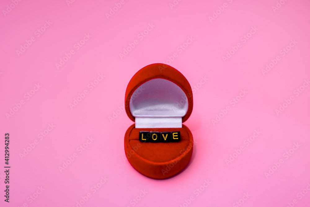 Gift case for a ring in the form of a red heart. It contains the word love in letters on cubes. The concept of congratulations on your wedding day, Valentine's day, March 8. Gift case for a ring in the form of a red heart. It contains the word love in letters on cubes. The concept of congratulations on your wedding day, Valentine's day, March 8.