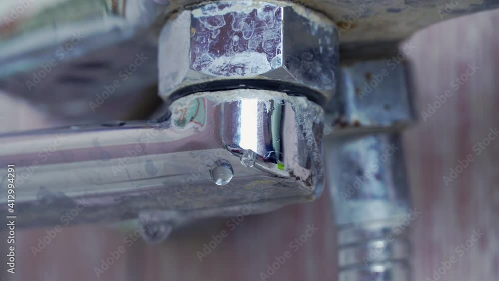 the old, rusty faucet in the bathroom is dripping. water drips from the