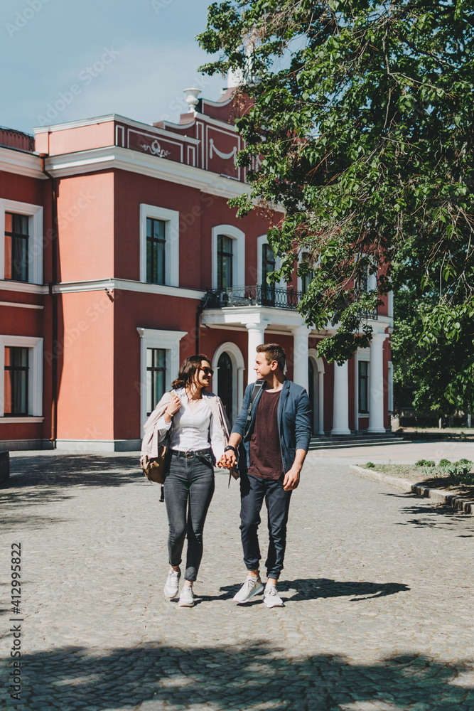 Travel couple, Romantic Destinations, Weekend Getaways, honeymoon for Couples. Happy young travellers woman and man with backpacks walks the streets of the city