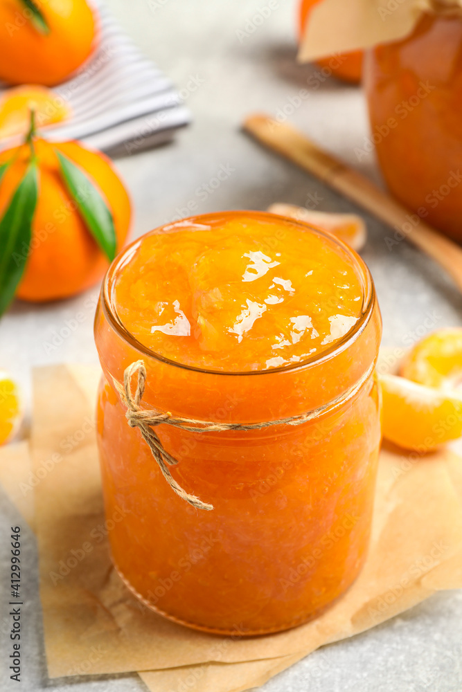 Delicious tangerine jam on light grey table, closeup Delicious tangerine jam on light grey table, closeup
