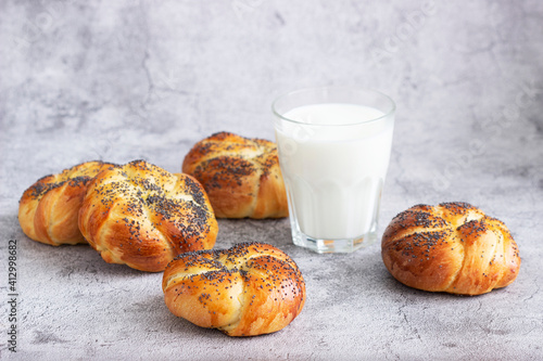 Sweet buns with poppy seeds served with milk. photo