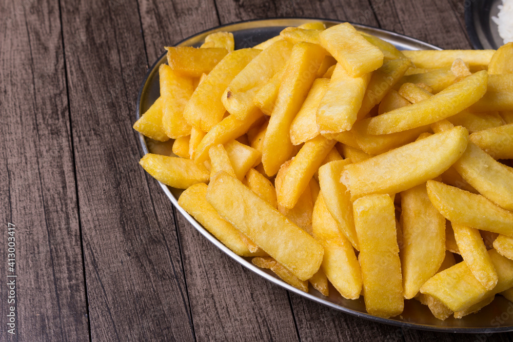 Portion of French fries served in popular bars and restaurants around the world.Gourmet photography of Frites. Popular gastronomy. Potatoes. Space for text for banner. Portion of French fries served in popular bars and restaurants around the world.Gourmet photography of Frites. Popular gastronomy. Potatoes. Space for text for banner.