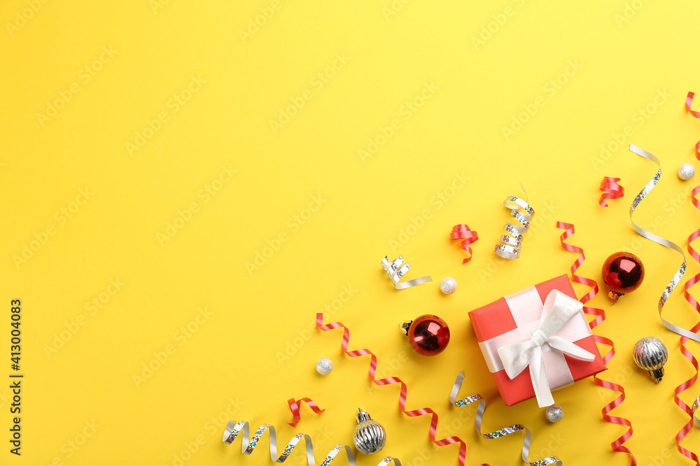 Flat lay composition with serpentine streamers and Christmas decor on yellow background. Space for text Flat lay composition with serpentine streamers and Christmas decor on yellow background. Space for text