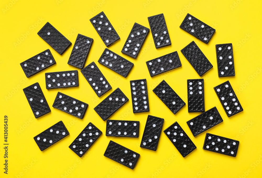 Black domino tiles on yellow background, flat lay Black domino tiles on yellow background, flat lay