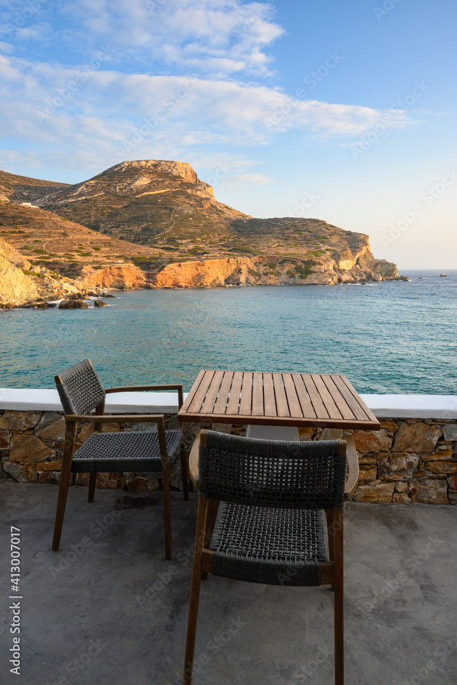 Table and chair overlooking Agali beach on Folegandros island. Cyclades, Greece