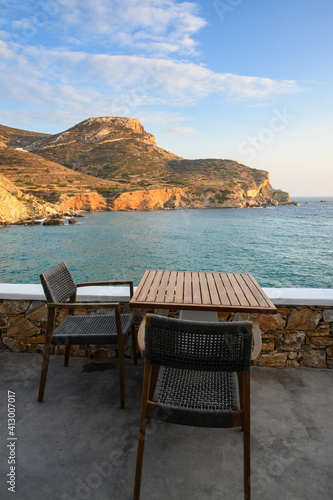 Table and chair overlooking Agali beach on Folegandros island. Cyclades, Greece © vivoo