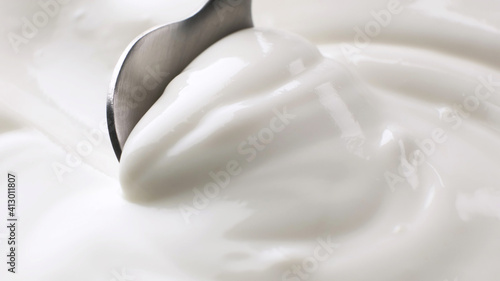 Sour cream close up, greek yogurt with spoon photo