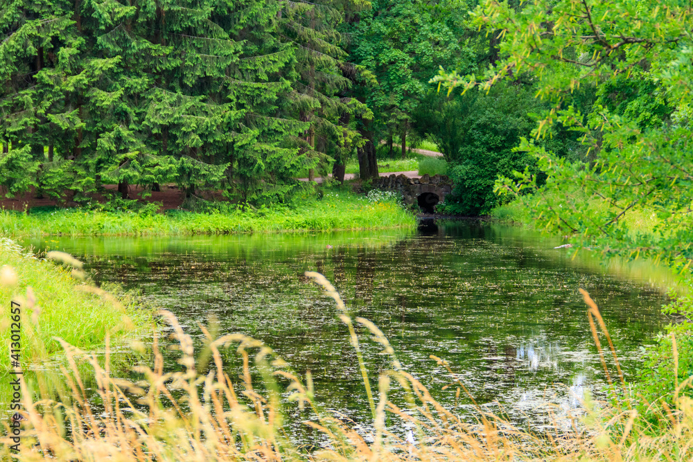 Obraz premium Stone arch bridge across a small river in Catherine park in Pushkin (Tsarskoye Selo), Russia