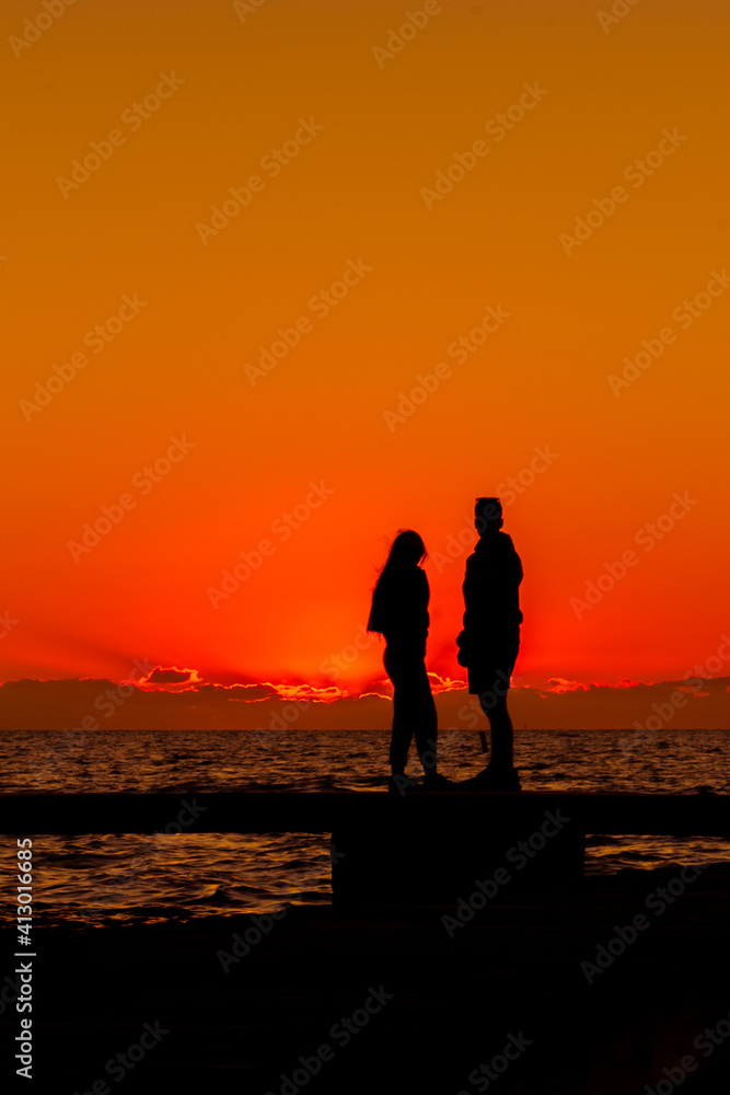 The silhouette of a young couple standing on a dock watching a spectacular Florida Keys sunset. The silhouette of a young couple standing on a dock watching a spectacular Florida Keys sunset.