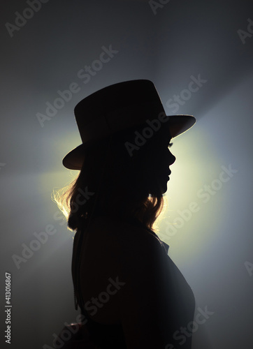 silhouette of a girl on yellow and gray backlight side view close-up