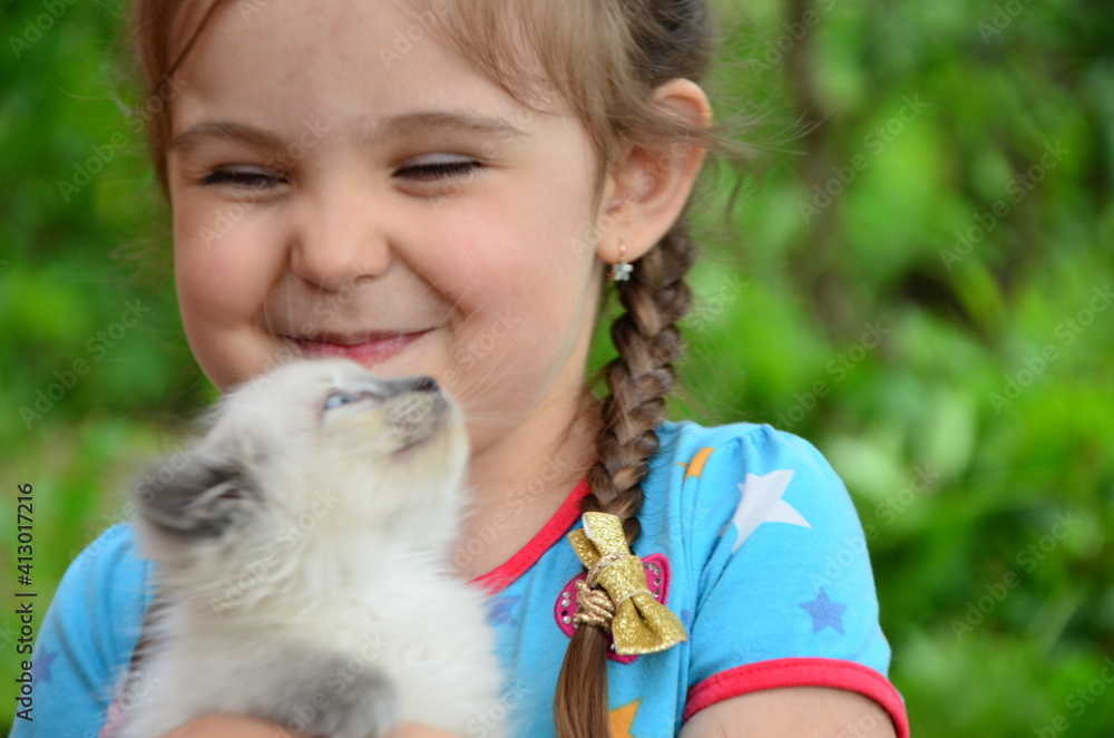 Little girl with a kitten in hands close up. Best friends. Interaction of children with pets. Little girl with a kitten in hands close up. Best friends. Interaction of children with pets.