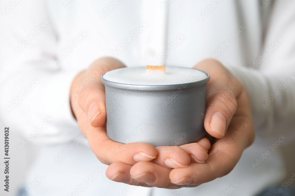 Woman holding candle with wooden wick, closeup Woman holding candle with wooden wick, closeup
