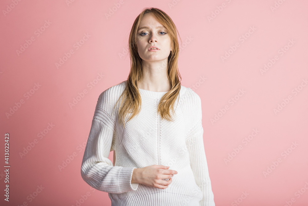 Fototapeta premium Portrait of a beautiful woman on a pink background in the studio