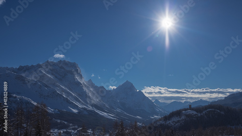 Fototapeta Naklejka Na Ścianę i Meble -  Early morning winter panorama of Valley around Cortina d'Ampezzo viewed from Tofana or ski piste above Cortina. Majestic mountains rising from the valley in sunrise.