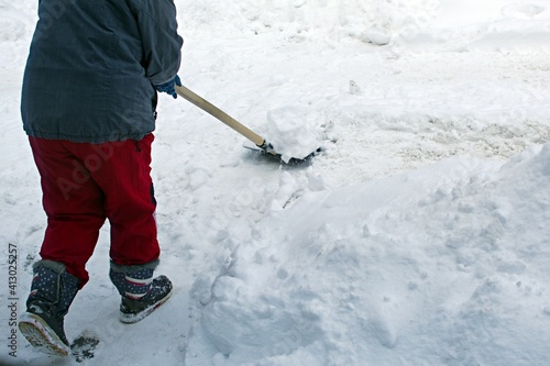 middle-aged woman shoveling freshly fallen snow