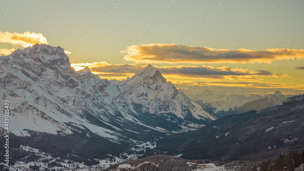 Early morning winter panorama of Valley around Cortina d'Ampezzo viewed from Tofana or ski piste above Cortina. Majestic mountains rising from the valley in sunrise.