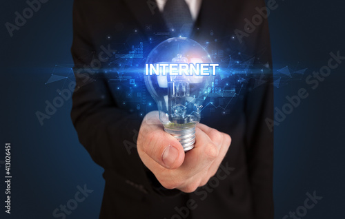 Businessman holding light bulb with INTERNET inscription, innovative technology concept