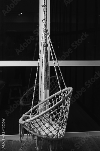 Hanging rocking chair hanging in front of the panoramic window © 4 Your Eyes