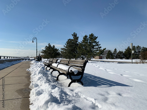 Vistas del camino y la playa nevados al borde del mar en un día soleado y muy frio