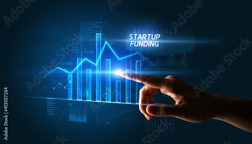 Hand touching STARTUP FUNDING button, business concept