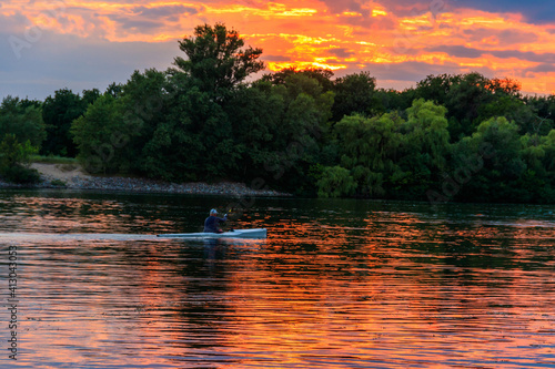 Man kayaking along the Dnieper river at sunset