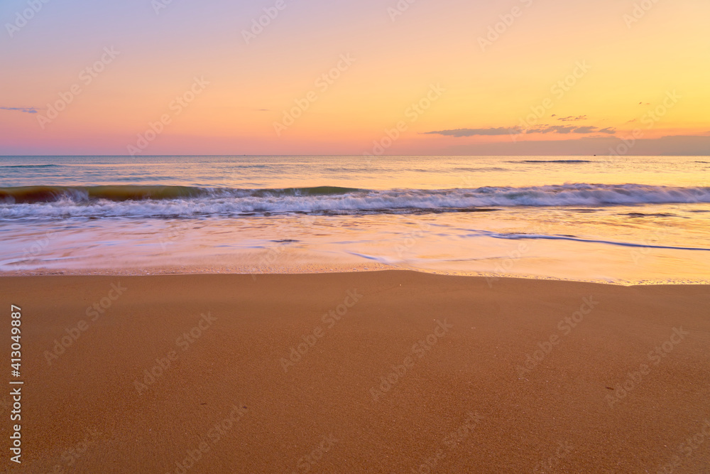 Sandy tropical beach at sunset as a backdrop.