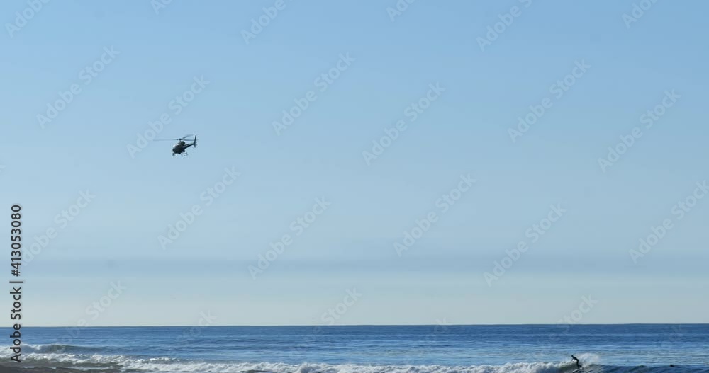 A police helicopter flying over the shoreline on the Pacific Ocean
A police helicopter flying over the shoreline on the Pacific Ocean