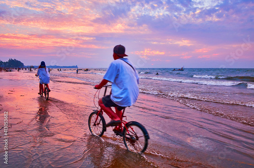 Cyclers on the beach, Chaung Tha, Myanmar photo