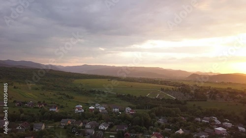 Aerial view of Nadvirna town with scattered houses and distant Carpathian mountain hills at sunset. photo