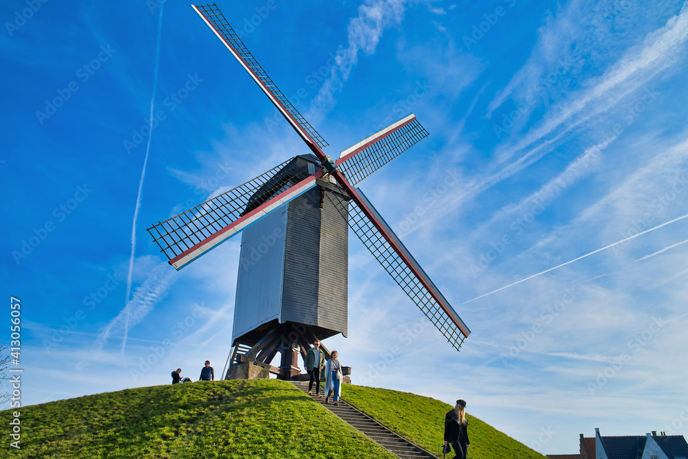 Bruges, Belgium - February 17, 2019: Sint-Janshuis Mill, windmill with few cloud and blue sky background