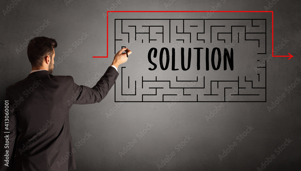 businessman drawing maze with SOLUTION inscription, business education concept businessman drawing maze with SOLUTION inscription, business education concept