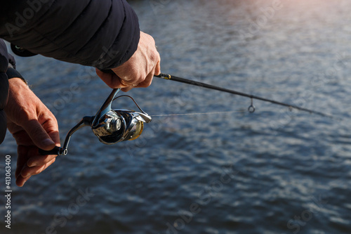 Fishing on the lake at sunset. Fisherman with rod, spinning reel on the river bank. Sunrise. Fishing for pike, perch, carp. Fog against the backdrop of lake.wild nature.