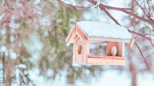 Obraz na płótnie Snow covered wooden bird feeder hanging in the winter forest w salonie