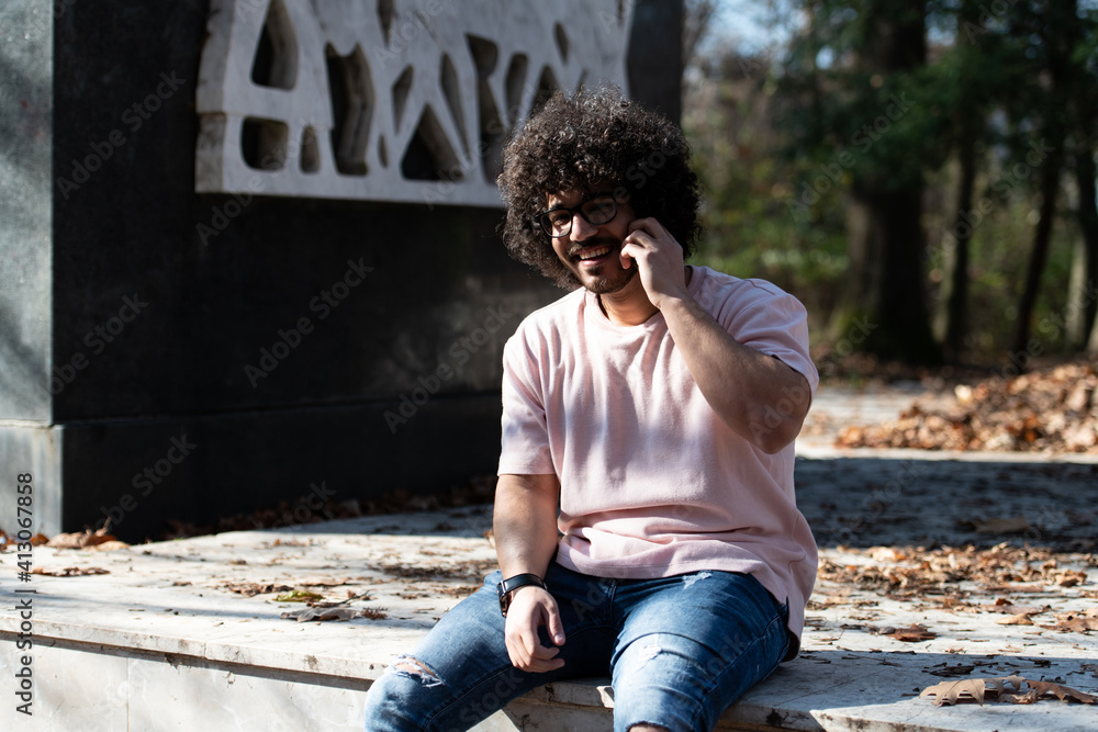 Bearded Smiling Man Touching Phone in Park