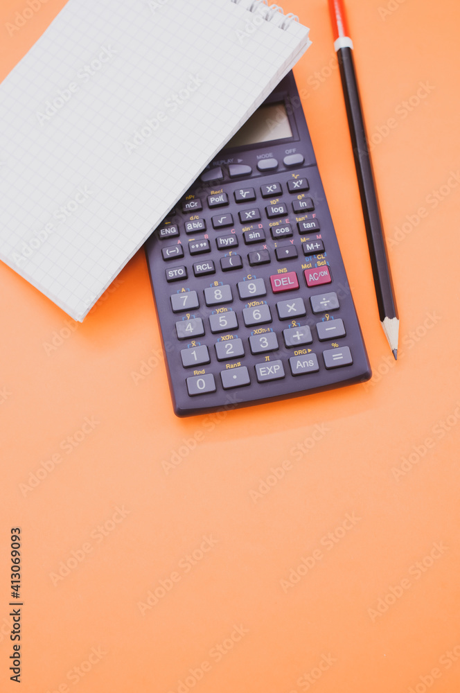 Vertical shot of a scientific calculator and a notepad on orange background  with space for your text Stock Photo | Adobe Stock