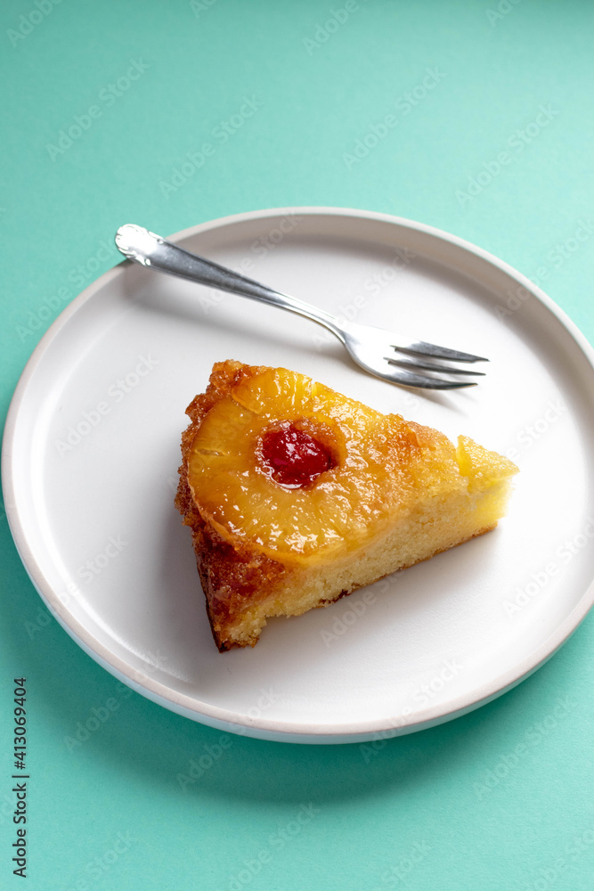 slice of pineapple upside down Cake with a fork on white plate slice of pineapple upside down Cake with a fork on white plate