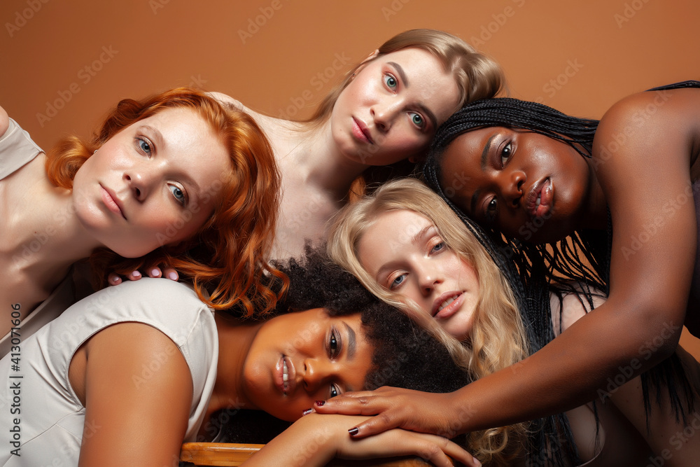 Fototapeta premium young pretty caucasian, afro, scandinavian woman posing cheerful together on brown background, lifestyle diverse nationality people concept