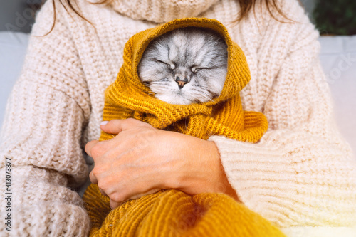 Canvas Print Woman in cozy sweater holding cute cat in plaid