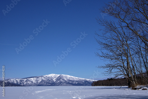 雪原の彼方に山を見る冬景色。