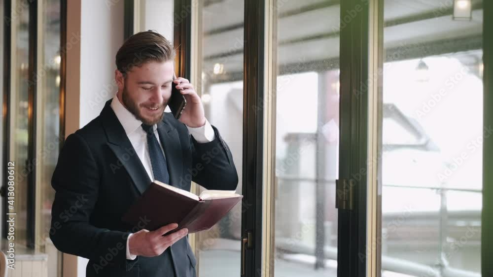 Side view of a smliling businessman talking on a phone being at cafe. Coffee break time. Side view of a smliling businessman talking on a phone being at cafe. Coffee break time.