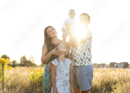 family in a field walking at sunset
