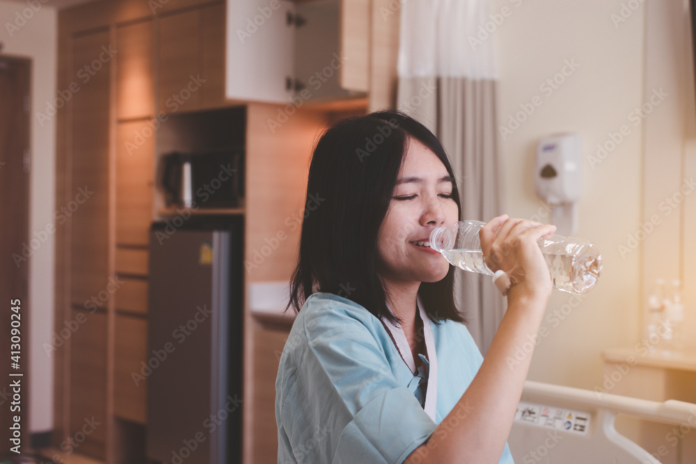 Patient asian woman drinking water during recovery at hospital Patient asian woman drinking water during recovery at hospital