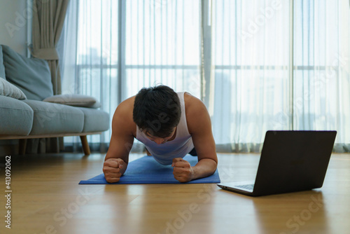 Asian men exercise at home by planking in gym closures during COVID-19 outbreak.