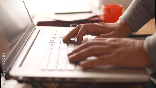 Close up of person fingers typing on laptop, business or education