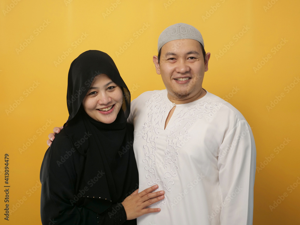 Portrait of happy Asian muslim couple smiling, husband and wife hugging full of love, family